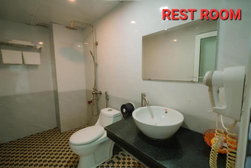 uma casa de banho com um lavatório, um WC e um espelho. em SAMMY Hotel - Khách sạn SAMMY em Giáp Vinh Yên