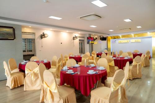 a banquet hall with red tables and chairs and a screen at SAMMY Hotel - Khách sạn SAMMY in Giáp Vinh Yên