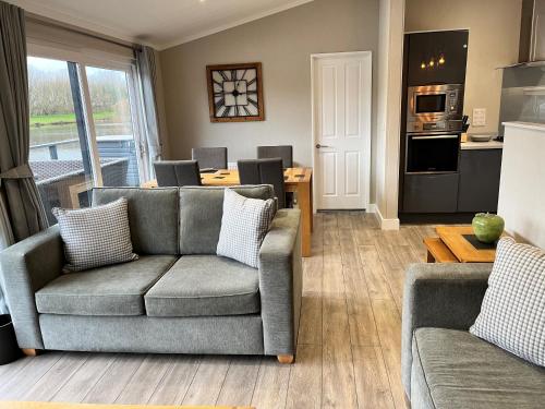 a living room with a couch and a table at Waterside Retreat Heron Lakes Nr Beverley in Beverley