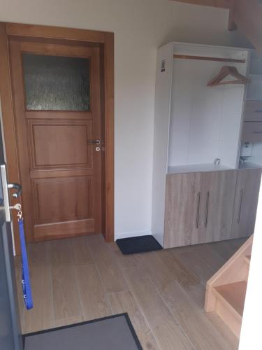 a kitchen with a wooden door and a wooden floor at Haus am Südhang in Bad Gottleuba