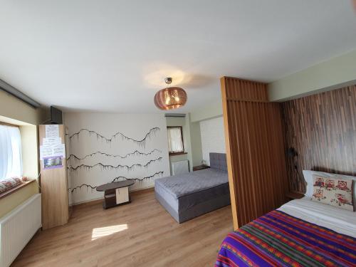 um pequeno quarto com uma cama e uma mesa em Forest Apartments em Sinaia