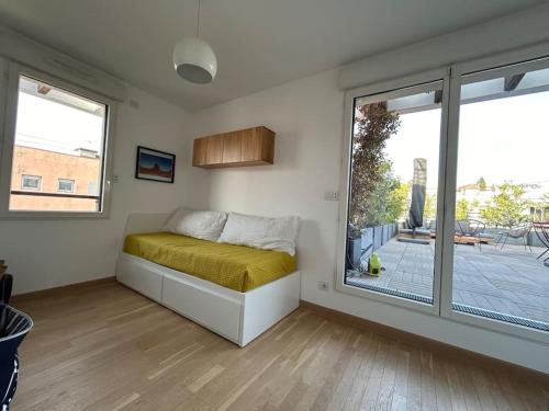 ein Schlafzimmer mit einem Bett und einem großen Fenster in der Unterkunft Duplex terrasses vue la Défense in Suresnes