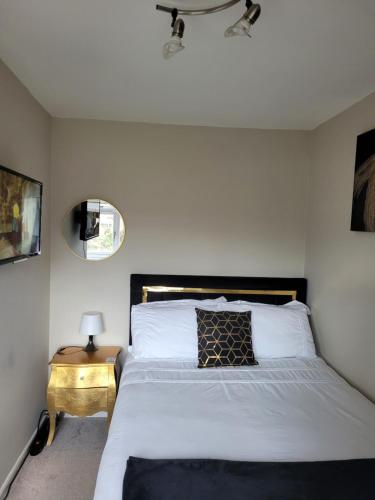 a bedroom with a bed and a side table with a mirror at NB's Cozy Nook in Shevington