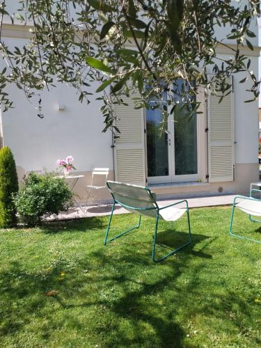 two chairs sitting in the grass in a yard at BEE HOME in Luni