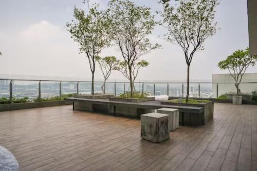 a balcony with benches and trees on top of a building at Sunway /Usj one Residence/ CozyHome/2bed room/2 Bath in Subang Jaya