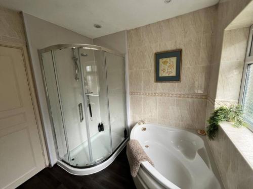 a bathroom with a shower and a white tub at 4 bed countryside home near Solihull & NEC - Sleeps 8 in Solihull
