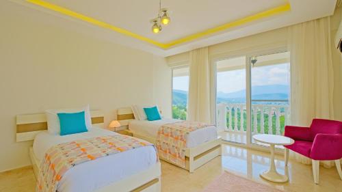 a bedroom with two beds and a balcony at Villa Bianca in Fethiye