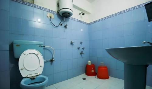 a blue bathroom with a toilet and a sink at Goroomgo Broadway Mall Road Darjeeling - Best Hotel in Darjeeling in Darjeeling