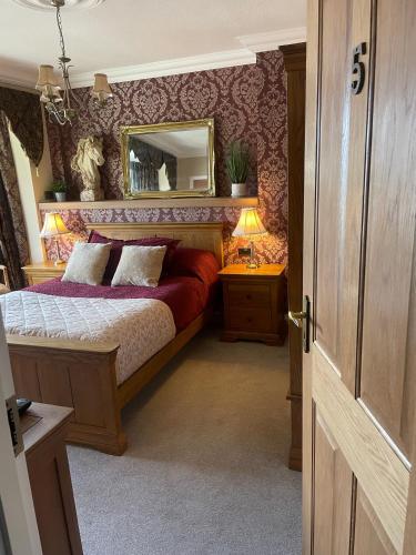 a bedroom with a bed with a mirror on the wall at Park View Apartment & Rooms in Scarborough