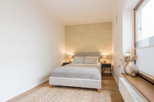 a bedroom with a white bed and a window at Old Town Deluxe Apartment in Tartu