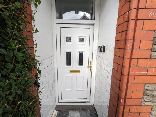 a white door with a window on a brick building at Inner-City Apartments - Basic Amenites in Cardiff