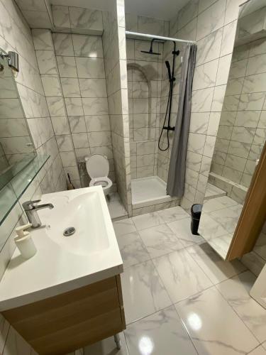 y baño con lavabo, ducha y aseo. en Luxury Apartments Paris en Le Bourget