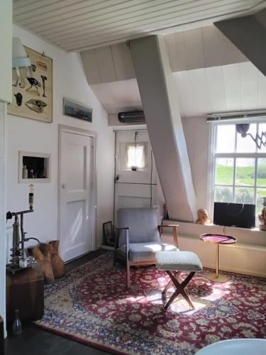 a living room with a chair and a window at Slapen bij de molenaar in Leerdam