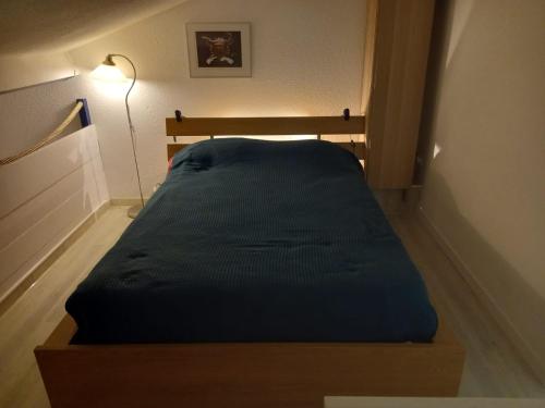 a bed in a small room with a lamp at Le duplex panoramic sur Mer et Lido in Sète