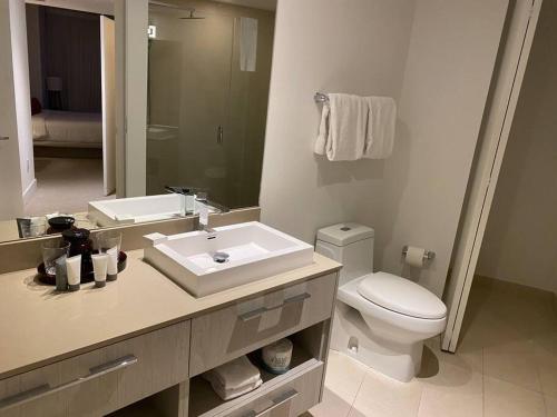 a bathroom with a sink and a toilet and a mirror at Amazing Ocean Views At Hyde Resort By rent4us in Hollywood