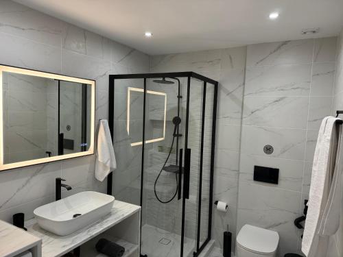a bathroom with a shower and a sink and a toilet at Central Suites Aegina 4 in Egina
