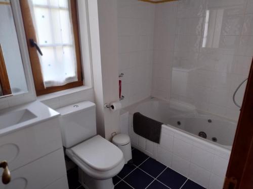 a bathroom with a toilet and a tub and a sink at Dúplex Somo Beach in Somo