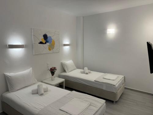 a bedroom with two beds and a painting on the wall at Central Suites Aegina 4 in Egina