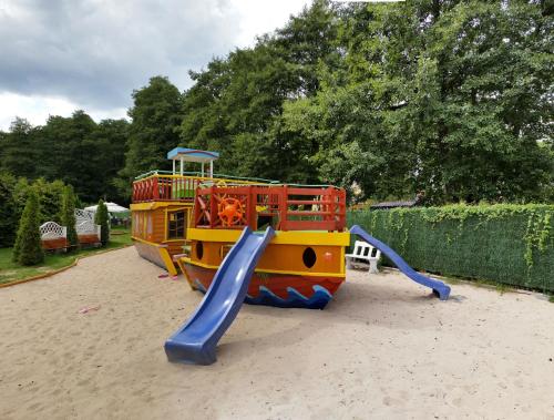 a playground with a slide in the sand at Domki Letniskowe Las Palmas Dąbki in Dąbki