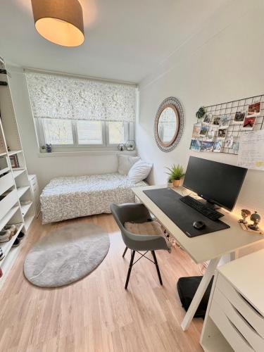 Cette chambre comprend un bureau avec un ordinateur et un lit. dans l'établissement Duplex cosy 53m2 pour les JO, à Viroflay