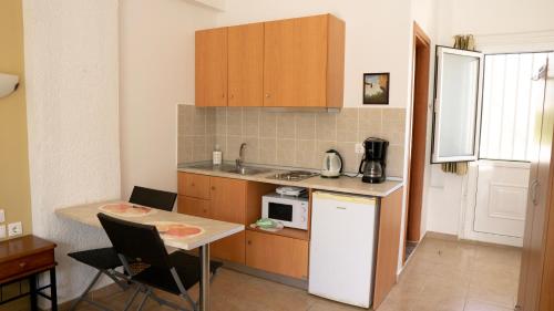a small kitchen with a table and a microwave at Seaside Studios Kirania in Kiotari