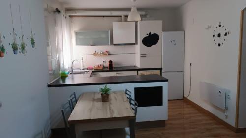 cocina con mesa y nevera blanca en Apartamento parque sur de Hellín en Hellín