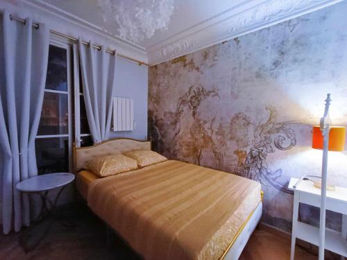 a bedroom with a bed and a painting on the wall at Au Petit Trianon Bleu in Versailles