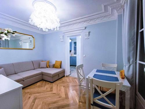 sala de estar con sofá y mesa en Au Petit Trianon Bleu, en Versalles