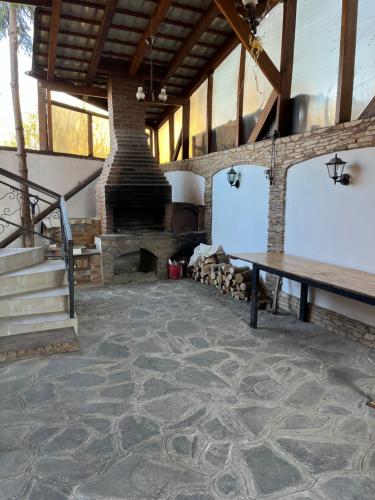 a large room with a stone fireplace and a wooden table at Random House in Braşov