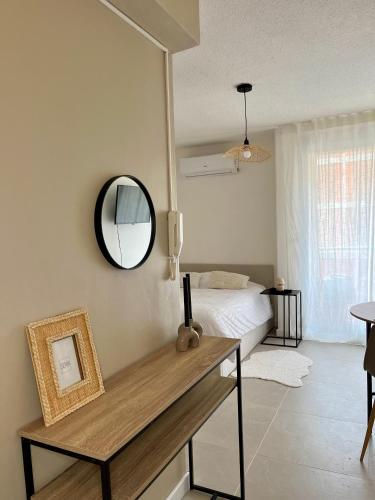 una camera da letto con un letto e uno specchio a parete di Appartement Balaruc les bains a Balaruc-les-Bains