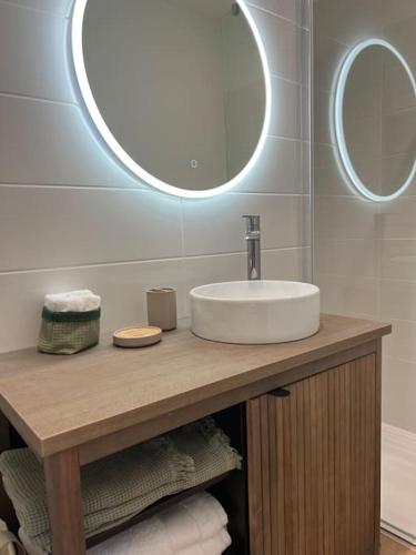 une salle de bain avec un lavabo et deux miroirs dans l'établissement Appartement de charme rénové avec garage, à Libourne