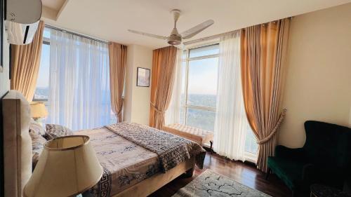 a bedroom with a bed and a large window at Centaurus Facing Executive Apartments By Elysium Tower Islamabad in Islamabad
