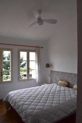 une chambre avec un grand lit et deux fenêtres dans l'établissement Villa le Hameau - Cap Esterel (Agay), à Saint-Raphaël