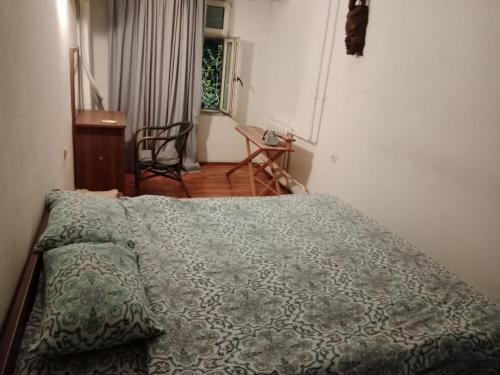 a bedroom with a bed with a green comforter at Apartment Tsentr 5 in Tashkent