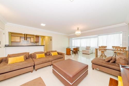 a living room with two couches and a table at Apto Amplo 1SUI+2Q Quadra Mar 50m da Praia in Balneário Camboriú