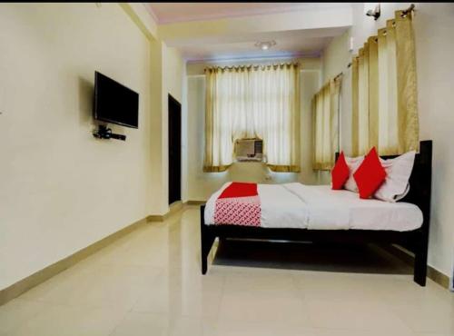 a bedroom with a bed with red and white pillows at AK VILAS - BEST BUDGETED HOTEL IN JAIPUR in Jaipur
