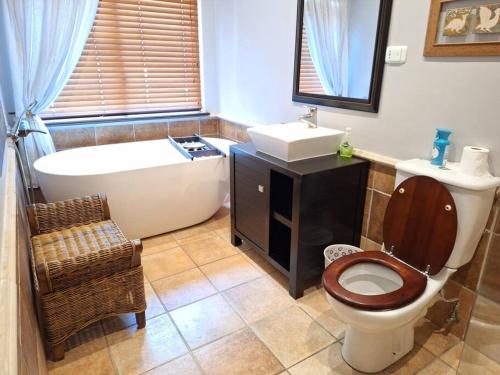 een badkamer met een bad, een toilet en een wastafel bij Zimbali 3 bedroom house in Ballito