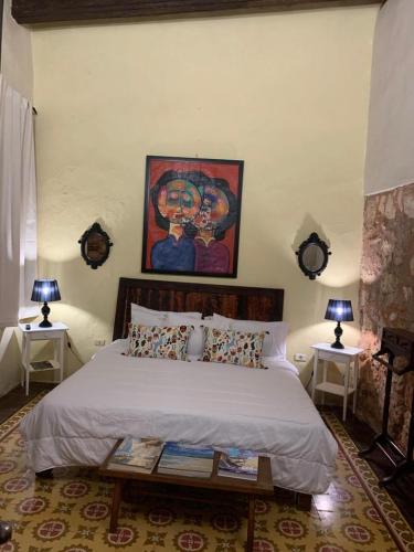 a bedroom with a bed and a painting on the wall at Mansion Colonial Boutique Hotel Pool Jacuzzi Bar Restaurant by BTC Group Crypto in Santo Domingo