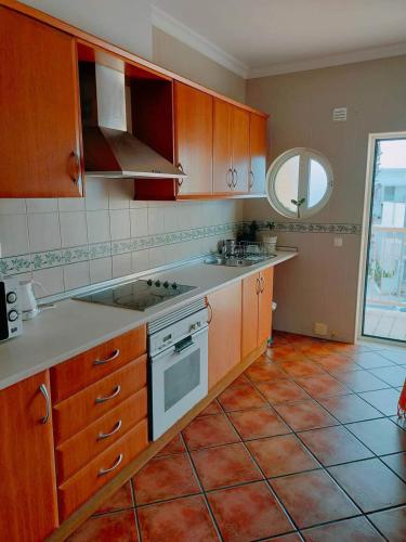 uma cozinha com armários de madeira e piso em azulejo em Holidays in Albufeira - Algarve em Albufeira