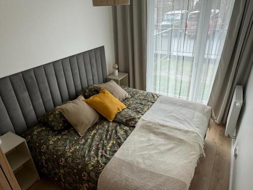 a bed with two pillows on it in a bedroom at Apartament Przystań 1 in Kartuzy