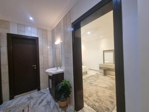 La salle de bains est pourvue d'un lavabo et d'un miroir. dans l'établissement شقه دور ارضي, à Al Muzāḩimīyah