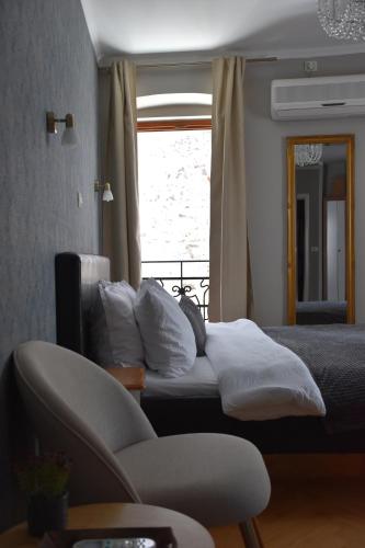 1 dormitorio con 1 cama, 1 silla y 1 ventana en Residence Dream, en Rovinj