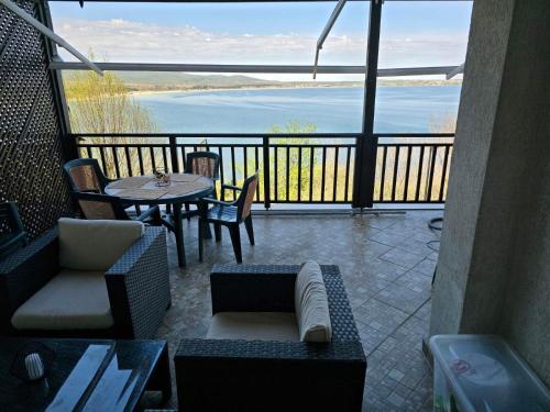 a balcony with a table and chairs and a view of the water at Sozopol Santa Marina Sea View Studio in Sozopol