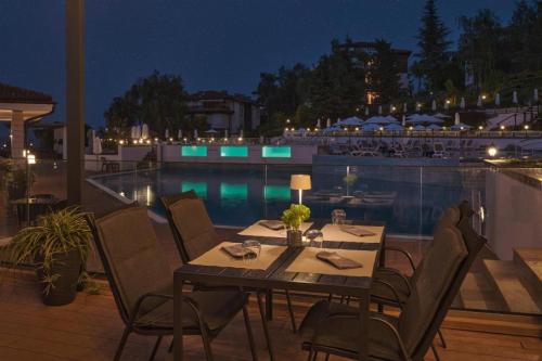 a table and chairs on a patio with a pool at Sozopol Santa Marina Sea View Studio in Sozopol