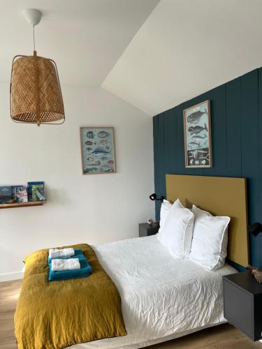 Un dormitorio con una cama con una pared de acento azul en Penty de Mézareun en Lampaul