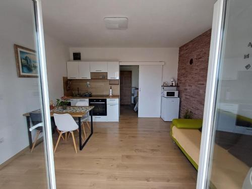 een keuken en een woonkamer met een tafel en stoelen bij Apartments Jelka in Rab