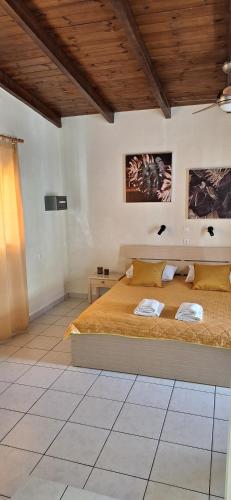 a bedroom with a large bed and a wooden ceiling at Nicolas Studios & Apartments in Agia Marina Nea Kydonias