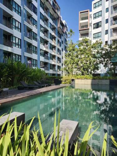 een zwembad voor sommige appartementsgebouwen bij Centrio Condominium Phuket in Ban Rangeng