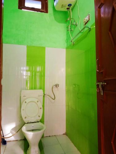 PīpalkotiにあるHotel MatrChaayaの緑と白のバスルーム(トイレ付)