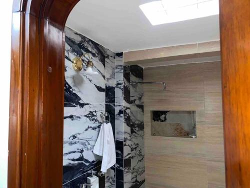 a bathroom with a black and white marble wall at Lujosa casa, excelente sector, amplia con piscina in Cúcuta